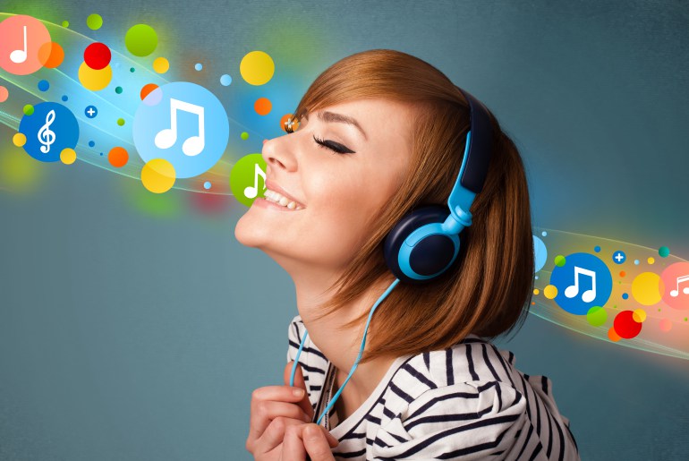 Pretty young woman with headphones listening to music, bubbles concept