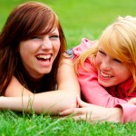 Two young teens relaxing in a park.