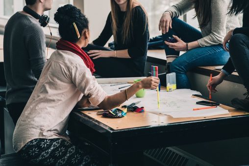 4 alumnes parlant al voltant d'una taula amb actitud informal