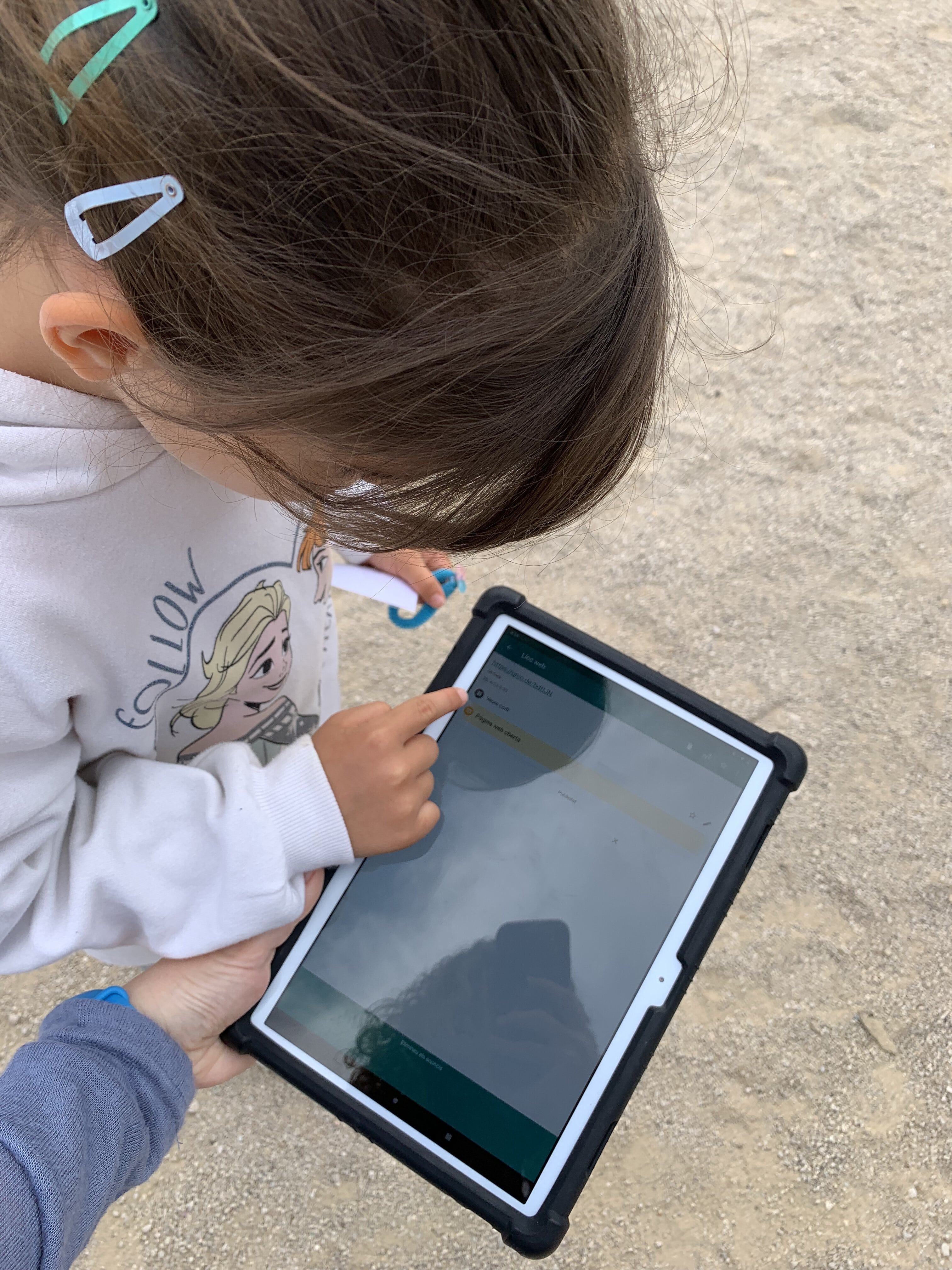 Nena seguint passos per llegir codis QR amb l'iPad