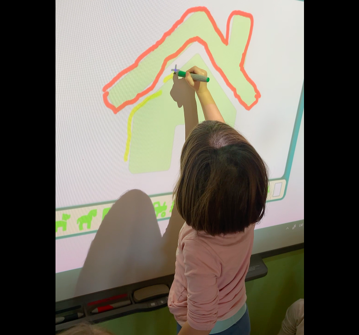 Nena realitzant una activitat de resseguir figures a la PDI